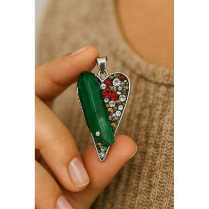 Hand holding heart-shaped emerald crystal pendant featuring colorful stones and silver detailing