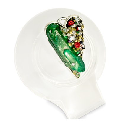 Angled view of emerald crystal heart pendant on clear jewelry stand