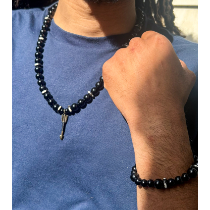 Man wearing black onyx and white earth bead jewelry set from Andrea’s Earth in natural sunlight.